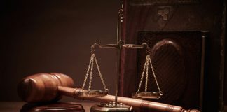 Para actuar ante órganos judiciales unipersonales, no basta la designación de letrado de oficio Balanza de justicia y un mazo