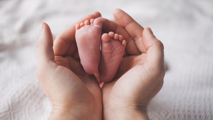 Pies de bebe sobre unas manos