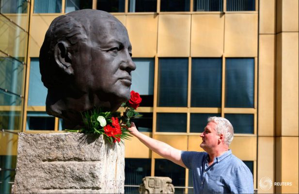 Un hombre coloca una rosa en una escultura de Mijaíl Gorbachov en memoria del líder final de la Unión Soviética, en el memorial de los "Padres de la Unidad" en Berlín, Alemania, el 31 de agosto de 2022. REUTERS/Lisi Niesner