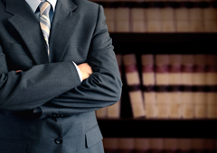Una persona con traje con libros jurídico al fondo
