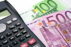 ¿Deben las comunidades de propietarios de inmuebles en régimen de propiedad horizontal pagar la tasa para el ejercicio de la potestad jurisdiccional? Una calculadora y billetes de euro