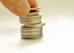 Unos dedos sobre un montoncito de monedas
