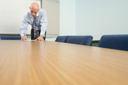 Un hombre de traje firmando un contrato sobre una mesa.