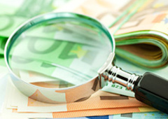 Una lupa y billetes de euro
