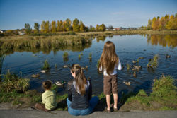 Una madre en un parque natural con sus dos hijos.