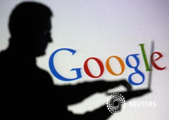 La silueta de una persona con un portátil delante de una pantalla con el logo de Google, en una foto tomada en Zenica el 29 de octubre de 2014