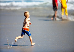Un niño corriendo hacia el mar.