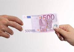 Una mano dándole un billete de 500 a otra mano