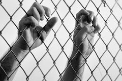¿Es contraria la prisión permanente revisable española a la jurisprudencia del Tribunal Europeo de Derechos Humanos? Unas manos agarrando una alambrada