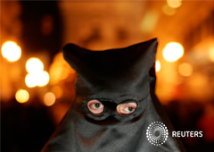 Un preso indultado participa como un penitente en una procesión de