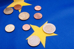 Establecimientos permanentes en el IVA Monedas de euro sobre bandera de la UE