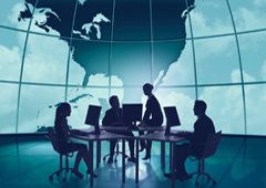 Personas reunidas alrededor de una mesa con el mapa del mundo de fondo