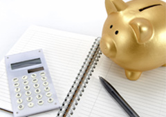 Cuaderno, calculadora y cerdito hucha dorado