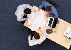 Tres personas trabajando sentadas en una mesa