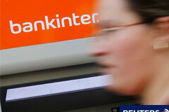 Un paso más para los inversores en productos islandeses Una mujer pasa delante de un cajero de Bankinter