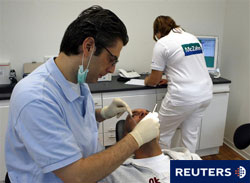 Un dentista en su consulta con un paciente