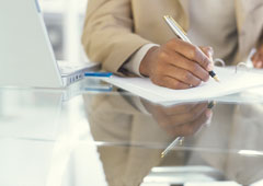 Una persona escribiendo en un documento.